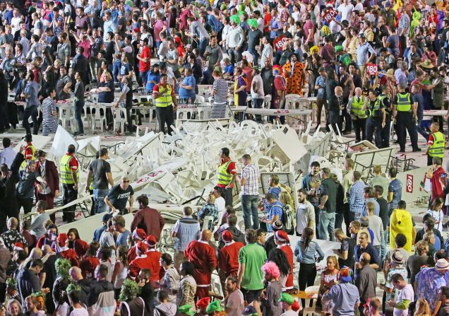 Security and police officers stand guard around a pile of plastic chairs and tables after spectators threw them during the finals of the Invitational Darts Challenge in Melbourne, Australia on January 10.