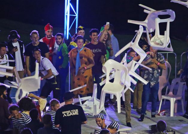 Dressed up spectators throw plastic chairs and tables during the Invitational Darts Challenge finals in Melbourne, Australia on January 10.