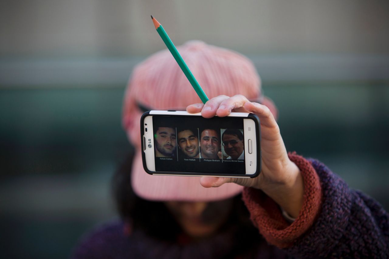A woman in Tel Aviv, Israel, holds a pencil Sunday, January 11, showing solidarity for the 12 people <a href="http://www.cnn.com/2015/01/07/world/gallery/paris-charlie-hebdo-shooting/index.html" target="_blank">who were killed in a shooting last week</a> at the Paris office of French satirical magazine Charlie Hebdo. Her cell phone shows four people <a href="http://www.cnn.com/2015/01/09/world/gallery/paris-grocery-standoff/index.html" target="_blank">who were killed in a Paris standoff</a> several days after the Charlie Hebdo attack.