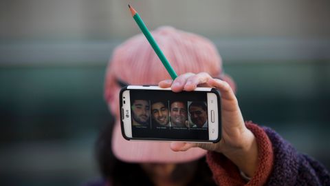 A woman in Tel Aviv, Israel, holds a pencil Sunday, January 11, showing solidarity for the 12 people <a href="http://www.cnn.com/2015/01/07/world/gallery/paris-charlie-hebdo-shooting/index.html" target="_blank">who were killed in a shooting last week</a> at the Paris office of French satirical magazine Charlie Hebdo. Her cell phone shows four people <a href="http://www.cnn.com/2015/01/09/world/gallery/paris-grocery-standoff/index.html" target="_blank">who were killed in a Paris standoff</a> several days after the Charlie Hebdo attack.