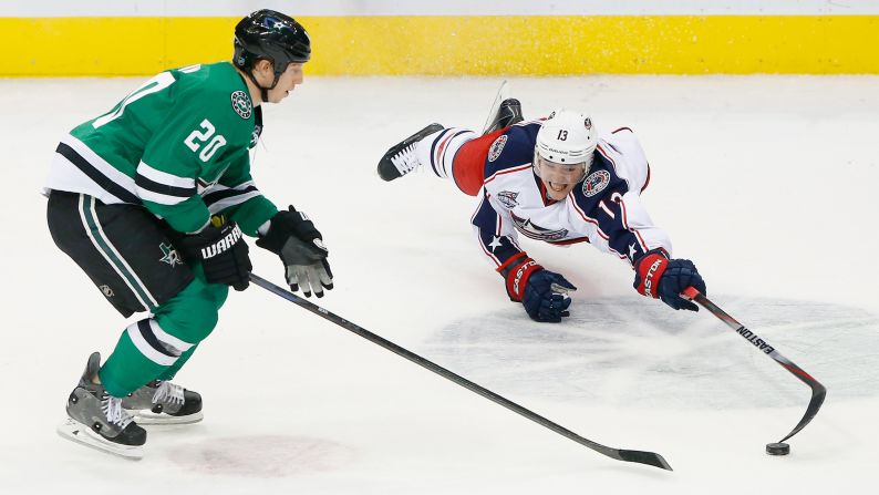 Cam Atkinson of the Columbus Blue Jackets dives for control of the puck while playing Cody Eakin and the Dallas Stars on Tuesday, January 6.