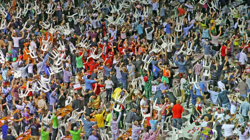 Fans raise plastic chairs above their heads during the final of the Invitational Darts Challenge, which took place Saturday, January 10, in Melbourne. Some fans <a href="index.php?page=&url=http%3A%2F%2Fwww.washingtonpost.com%2Fblogs%2Fearly-lead%2Fwp%2F2015%2F01%2F10%2Finternational-darts-tournament-in-australia-gets-insane-when-fans-start-massive-brawl%2F" target="_blank" target="_blank">threw their chairs</a> at one another, starting a fight.