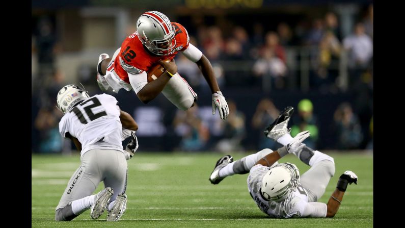 Ohio State quarterback Cardale Jones dives over two Oregon defenders during the national championship game Monday, January 12.
