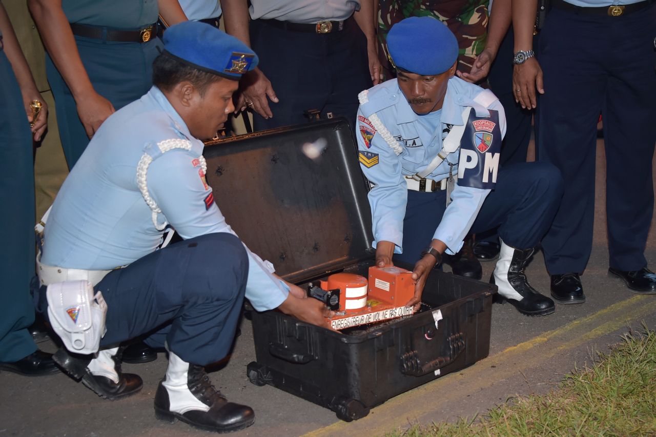 Indonesian officials remove the cockpit voice recorder from AirAsia Flight QZ8501 on Tuesday, January 13. Indonesian divers retrieved it from beneath the wreckage of the plane.