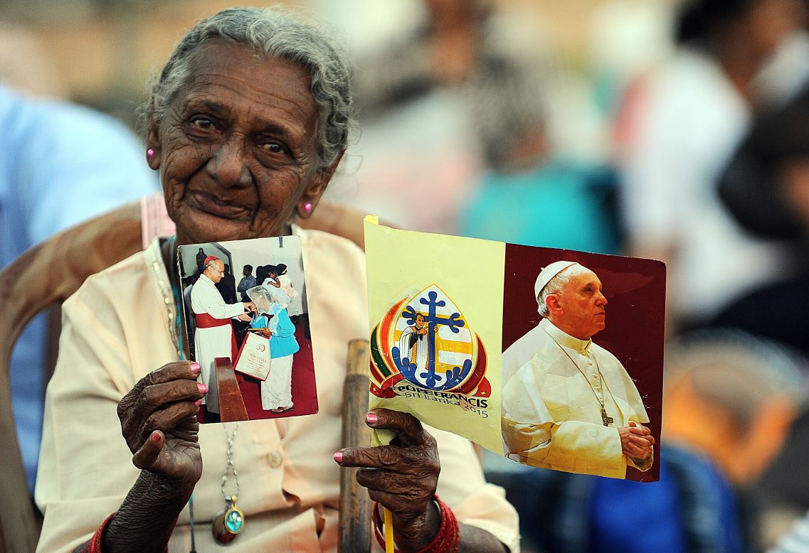 A Sri Lankan woman holds a flag bearing a portrait of Pope Francis.