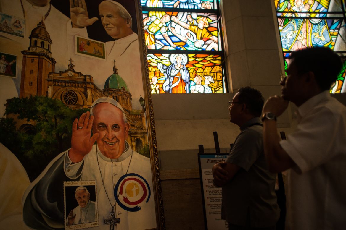 Parish priests look at a montage of paintings of Pope Francis adorning a section of Manila Cathedral on January 7 in Manila, Philippines. 