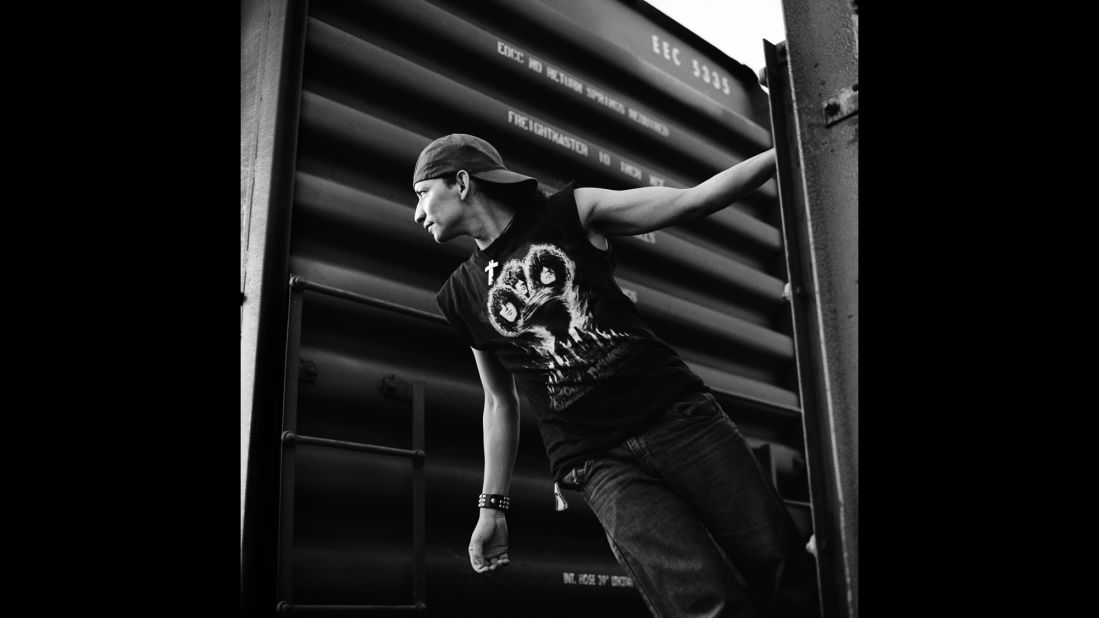 A Salvadoran migrant hangs off the back of a cargo train in Arriaga, Mexico, in July 2010.