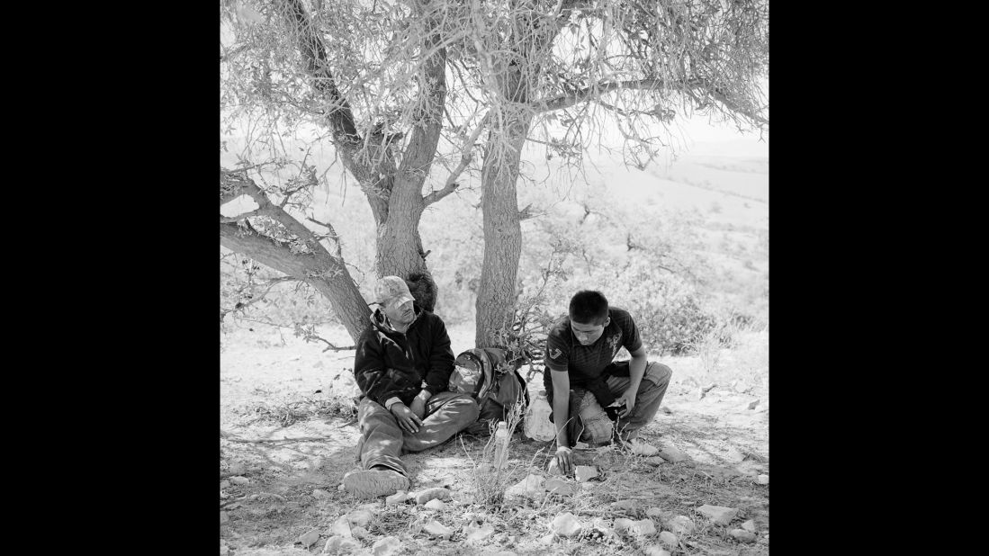 Migrants rest in the shade of a mesquite tree in May 2012.