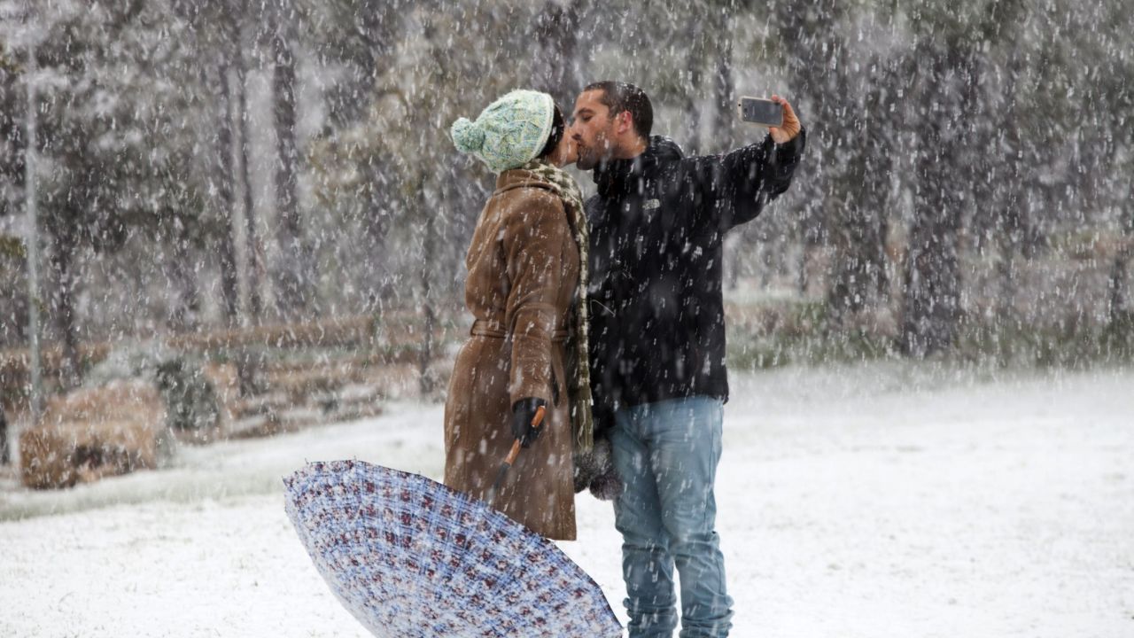 A couple shares a kiss Friday, January 9, in a snow-covered park in Jerusalem.