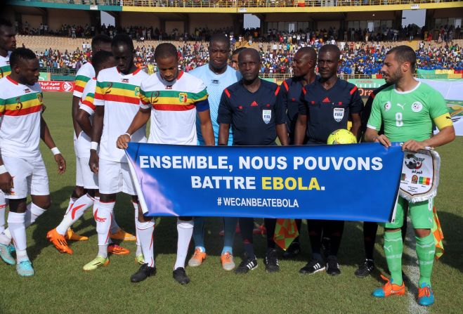 Mali and Algeria players hold a banner uniting against Ebola during a Africa Cup of Nations qualifying match in November.