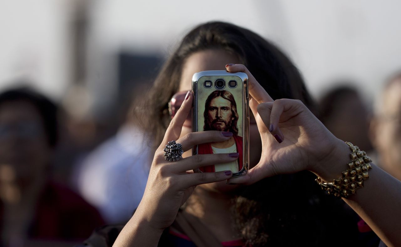 Jesus Christ is seen on the cell phone case of a woman waiting for the pope's arrival in Colombo.