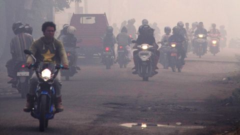 People wear masks as they ride through haze pollution on February 23, 2014 in Pontianak, Kalimantan, Indonesia.