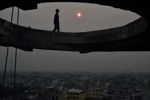 March 1 2014, In Medan, Indonesia, construction workers toil in the setting sun as smoke from fires in Riau province covers the region. The province was at the heart of a Southeast Asian smog crisis in 2013 and declared a state of emergency in February 2014 after being blanketed in a thick haze from forest fires.