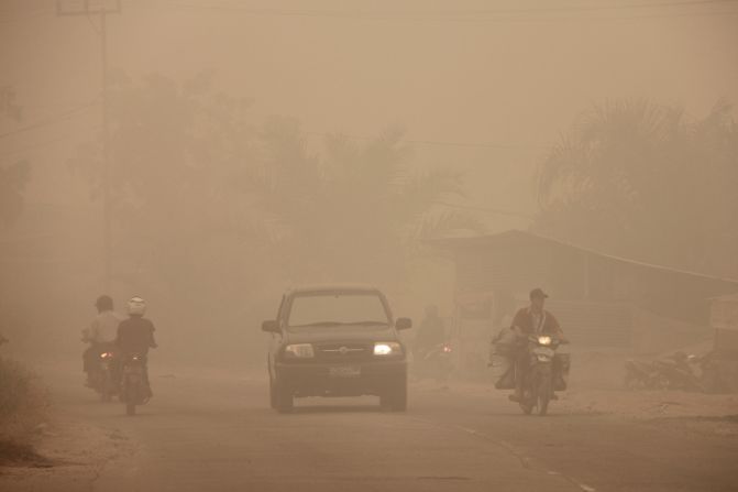 Indonesian motorists travel under a blanket of haze in Dumai town, Riau province, March 3, 2014. 