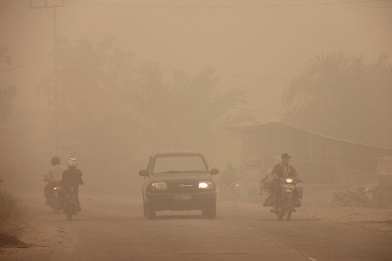 Indonesian motorists travel under a blanket of haze in Dumai town, Riau province, March 3, 2014. 