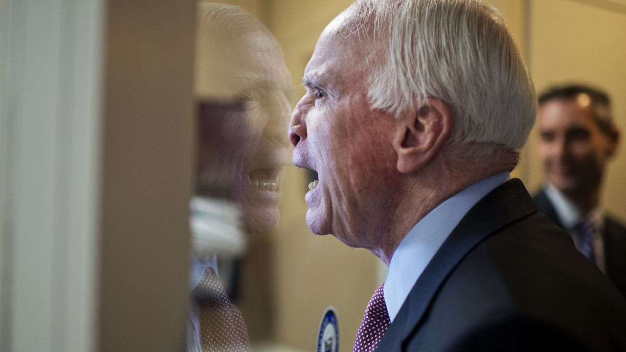 U.S. Sen. John McCain fools around with colleagues upon arriving at a news conference in Washington on Tuesday, January 13.