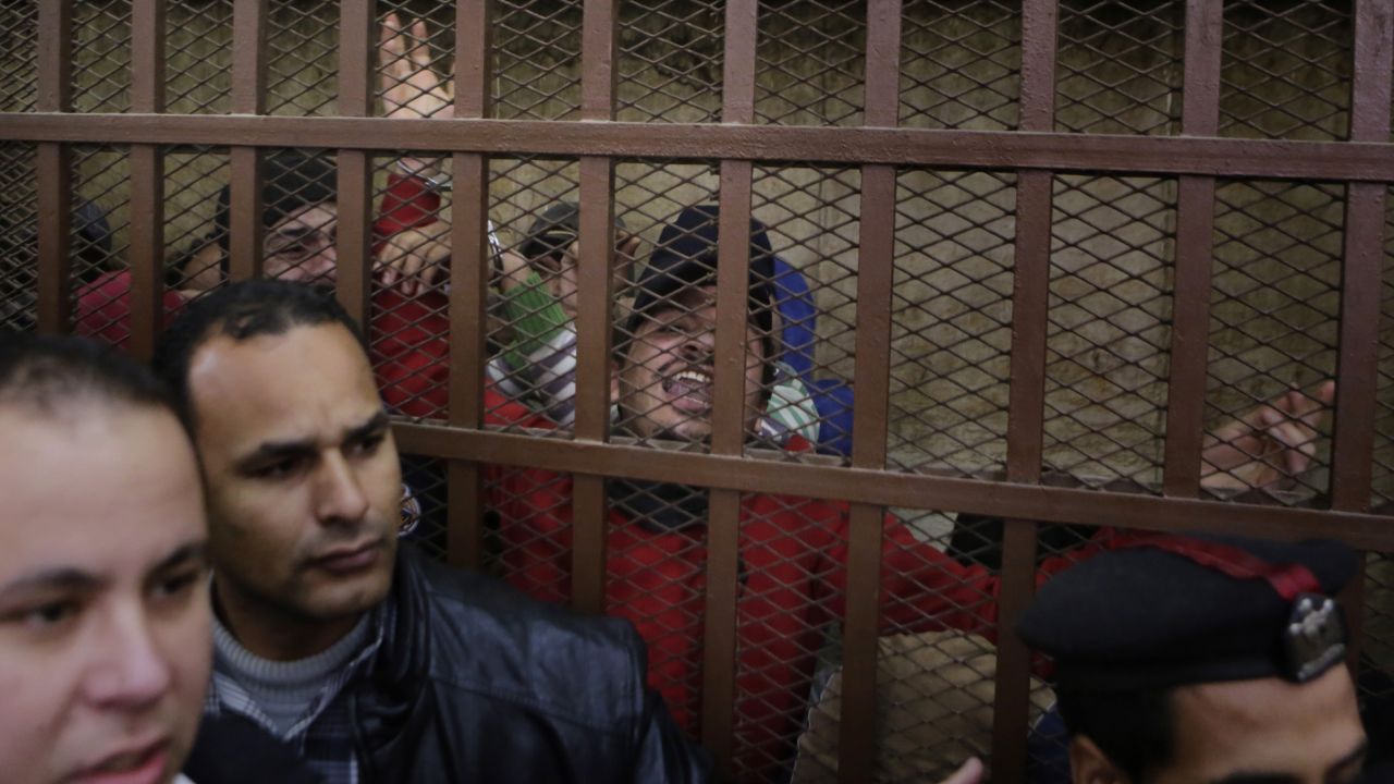 Police surround a courtroom cell in Cairo as men celebrate being acquitted of "debauchery" on Monday, January 12. The 26 men were arrested last month by police looking for gay people at a public bathhouse. The arrests caused an uproar among activists and rights groups.