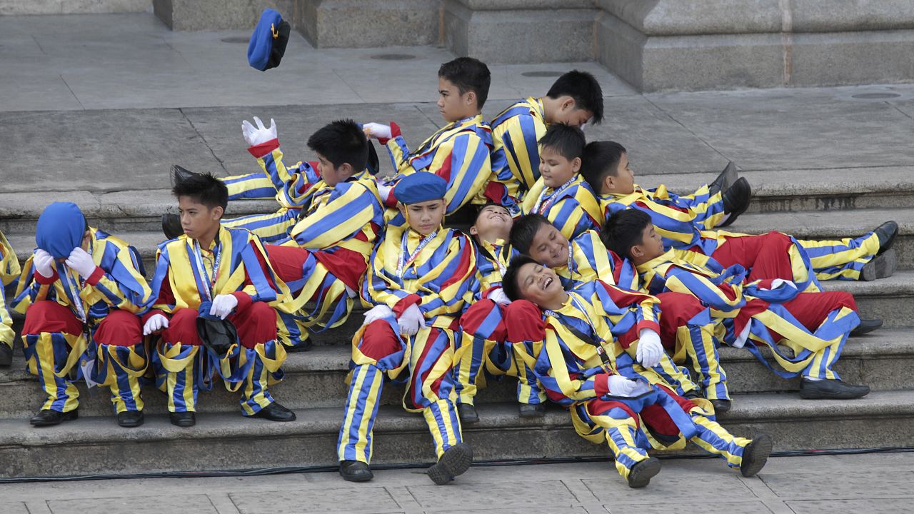 Boys dressed as the Swiss Guard rest January 16 as they wait for Pope Francis' arrival at the Cathedral Basilica of the Immaculate Conception in Manila.
