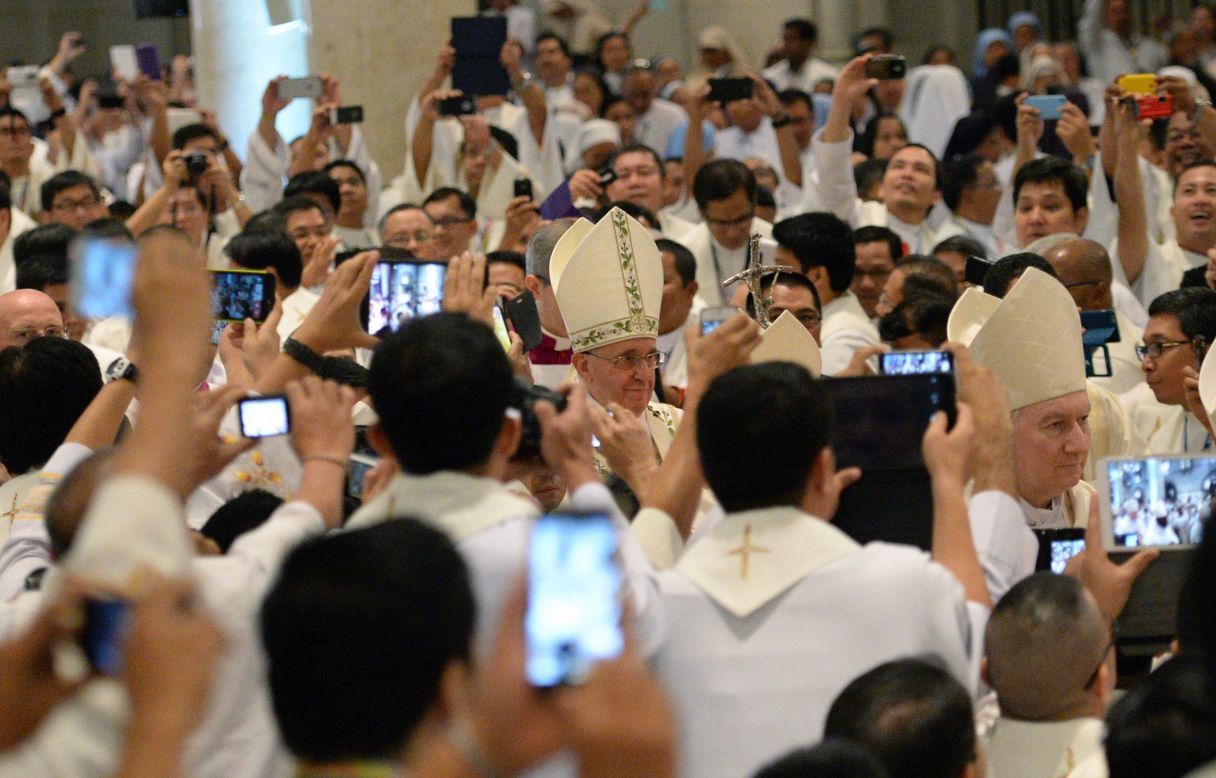 JANUARY 16 -- MANILA, PHILIPPINES: Catholic priests take smartphone photos of Pope Francis (C) as he enters for mass at the Manila cathedral.