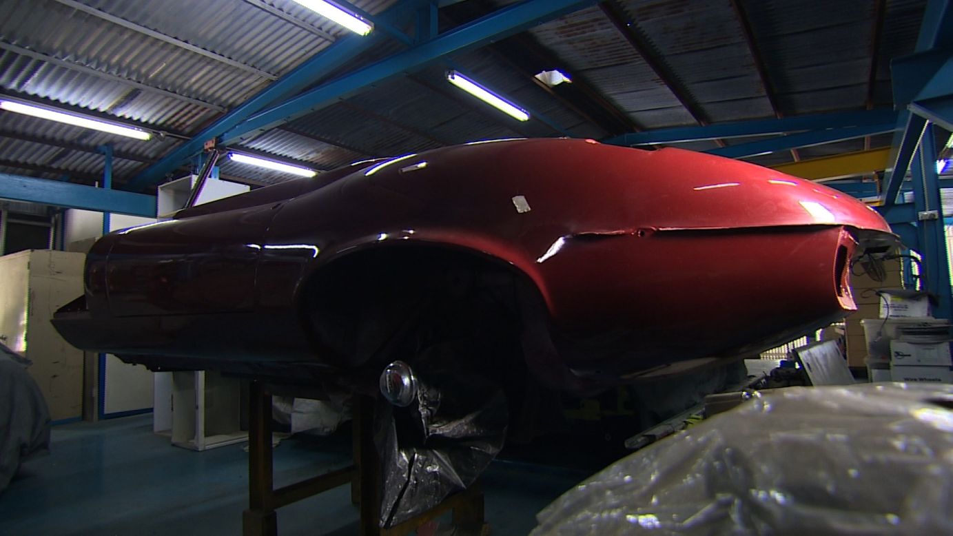 He heavily invests in the maintenance of his cars, such as this deep red Jaguar from the 1970s which is currently being repaired. 