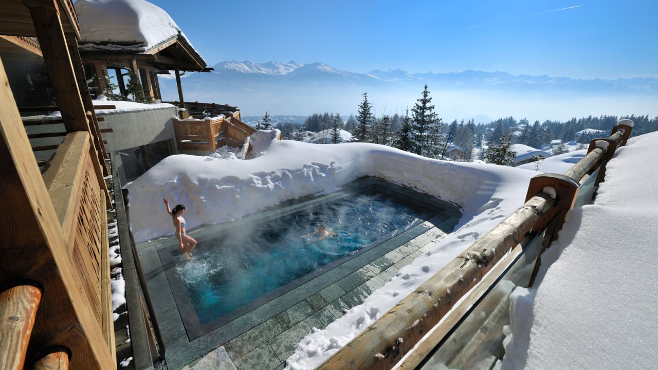 La piscina exterior climatizada de LeCrans ofrece sensacionales vistas de los Alpes suizos que la rodean. 