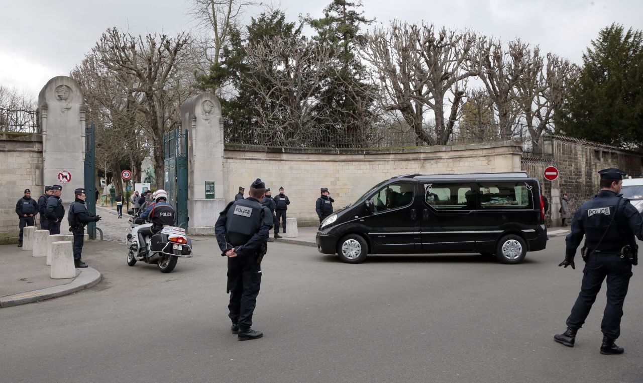 Police stand by as a hearse carrying Mustapha Ourrad's coffin arrives at the Pere Lachaise cemetery in Paris on Friday, January 16. Ourrad, a copy editor for the satirical magazine Charlie Hebdo, was one of 12 people killed in a <a href="http://www.cnn.com/2015/01/07/world/gallery/paris-charlie-hebdo-shooting/index.html" target="_blank">terror attack</a> on the magazine's office.
