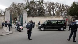 Police stand by as a hearse carrying the Ourrad's coffin  arrives at Pere Lachaise cemetery in Paris on January 16.
