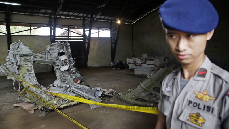A police officer stands guard near pieces of the plane's wreckage at a warehouse in Pangkalan Bun, Indonesia, on Monday, January 19.