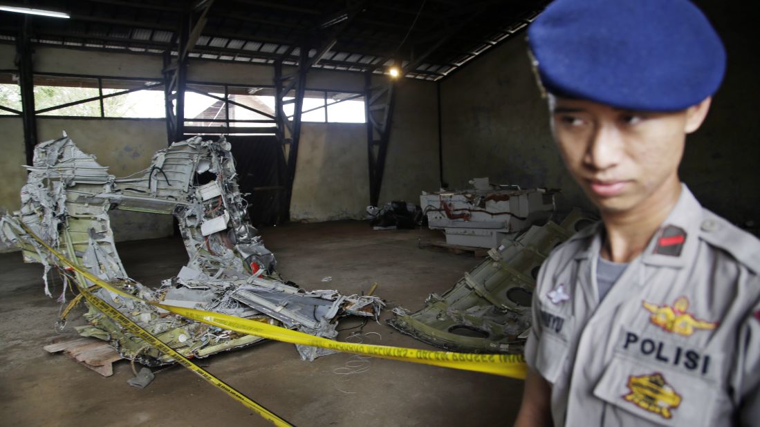 A police officer stands guard near pieces of the plane's wreckage at a warehouse in Pangkalan Bun, Indonesia, on Monday, January 19.