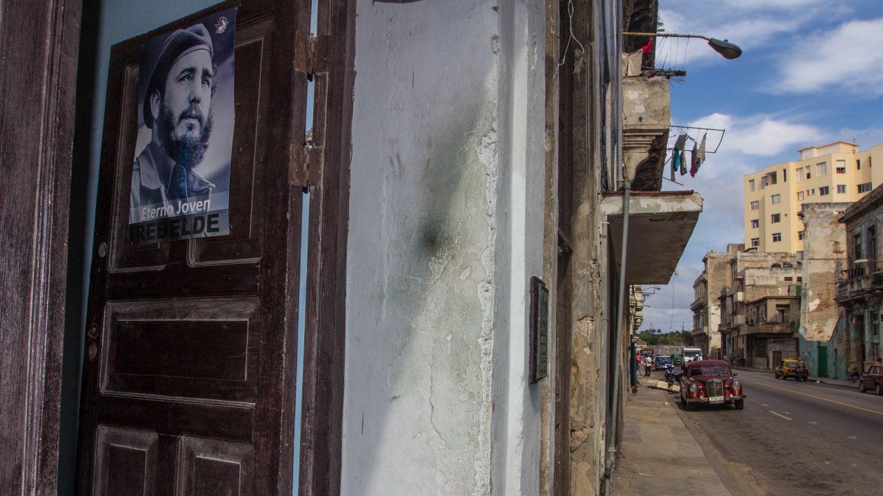 A Fidel Castro poster is on the door but nearby alcoholics look for a fix of rum.