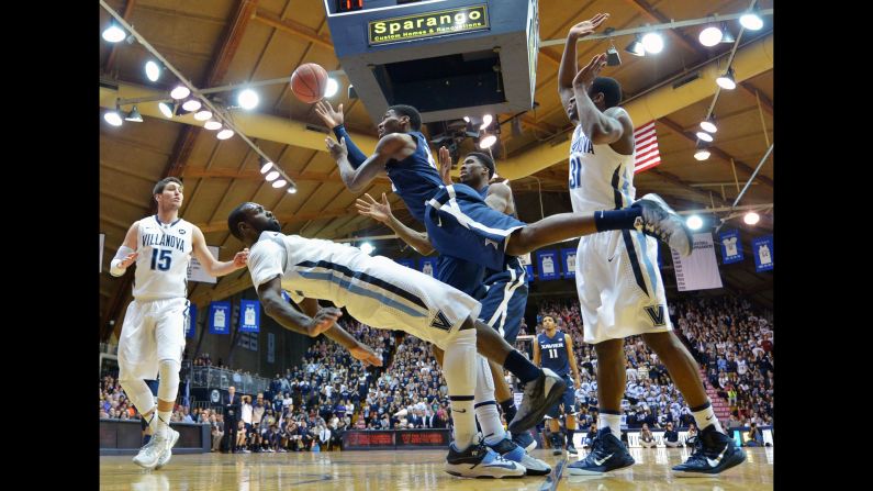 Villanova's Daniel Ochefu falls backward as he tries to draw a charge from Xavier's Remy Abell during a Big East conference game Wednesday, January 14, in Philadelphia. Villanova, one of the top-ranked teams in the nation, won 88-75.