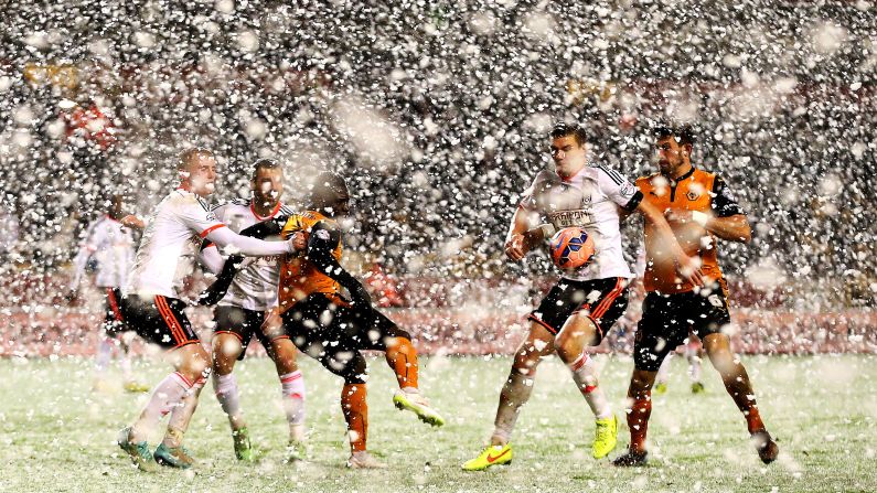 Players from English soccer clubs Wolverhampton and Fulham compete in heavy snow Tuesday, January 13, during an FA Cup replay match in Wolverhampton, England. Fulham advanced on penalties.