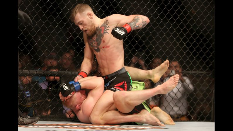 Conor McGregor punches Dennis Siver during their UFC bout in Boston on Sunday, January 18. After winning by second-round TKO, McGregor jumped over the cage's fence and confronted longtime featherweight champion Jose Aldo.