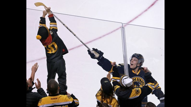 Boston Bruins rookie David Pastrnak tosses a souvenir stick to a fan after his two-goal performance against Tampa Bay on Tuesday, January 13. 
