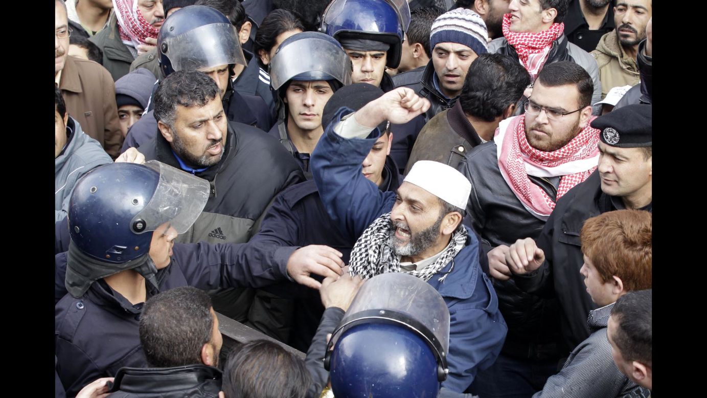 Members of Jordanian security services surround a protester in Amman on Thursday, January 15.