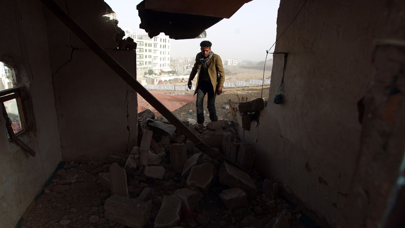 A man walks inside a heavily damaged house near the presidential palace on Tuesday, January 20.