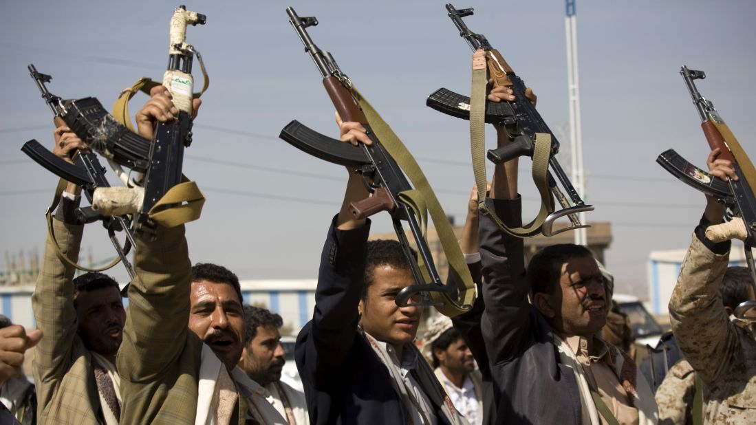 Houthi men raise their weapons during clashes near the presidential palace on Monday, January 19.