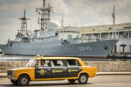 A Soviet-made Lada limousine passes by the Russian warship CCB-175 Viktor Leonov docked in 2014 in Havana.