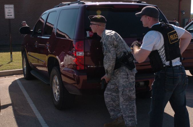 In this handout photo provided by the U.S. Army, police take cover as Nidal Hasan opens fire in Fort Hood, Texas, on November 5, 2009. The Army psychiatrist was convicted of killing 13 people.