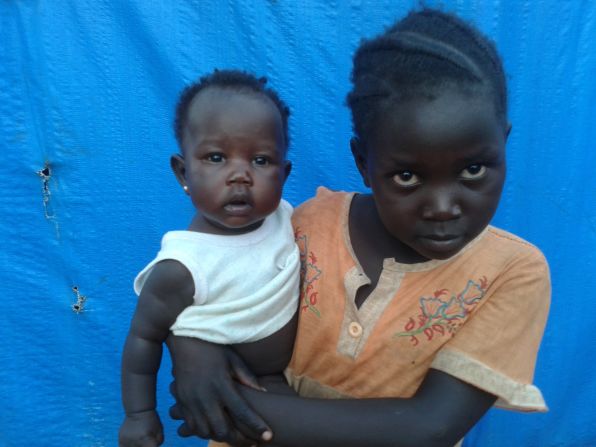 <br />"The babysitter is surprised to be photographed. The mother is denying this young girl the right to education by having her look after her little sister."