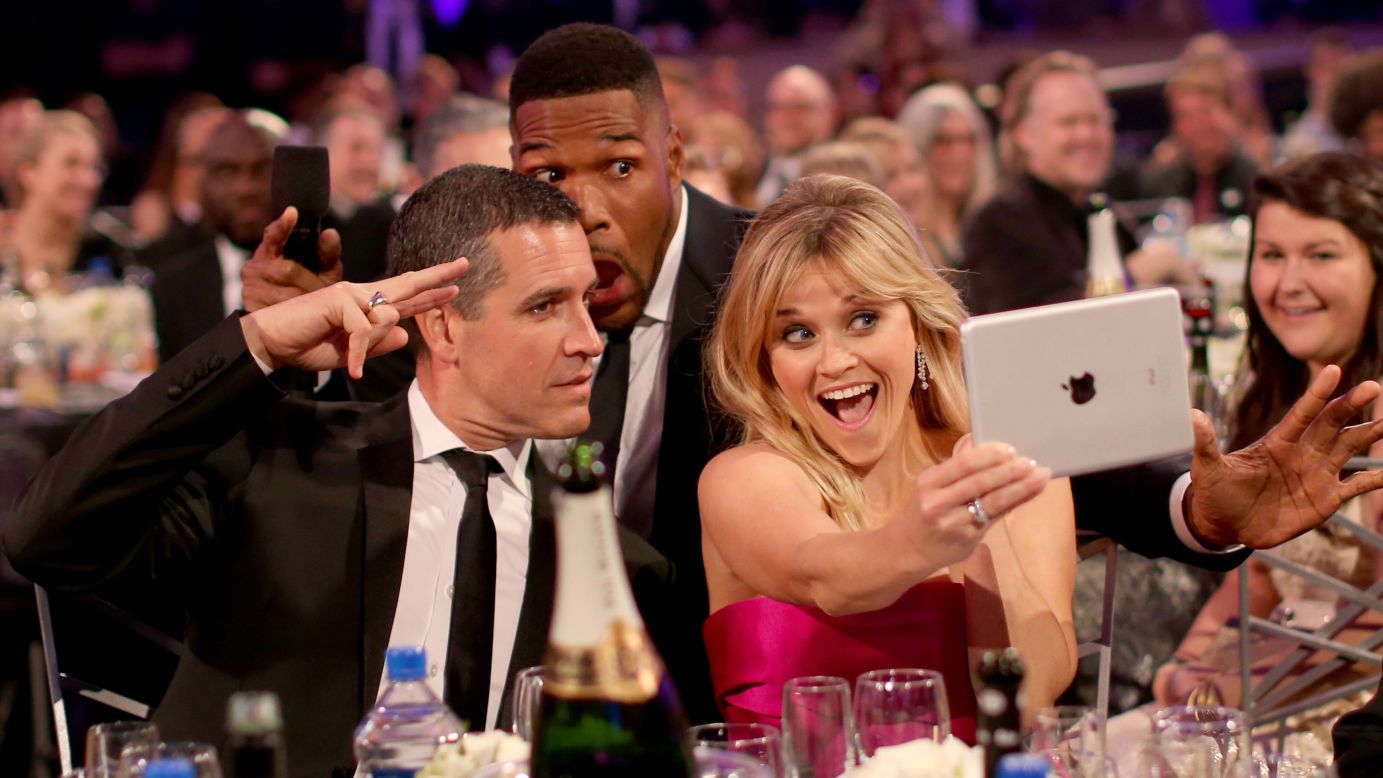 At the Critics' Choice Movie Awards, actress Reese Witherspoon snaps a selfie with husband Jim Toth, left, and show host Michael Strahan on Thursday, January 15.