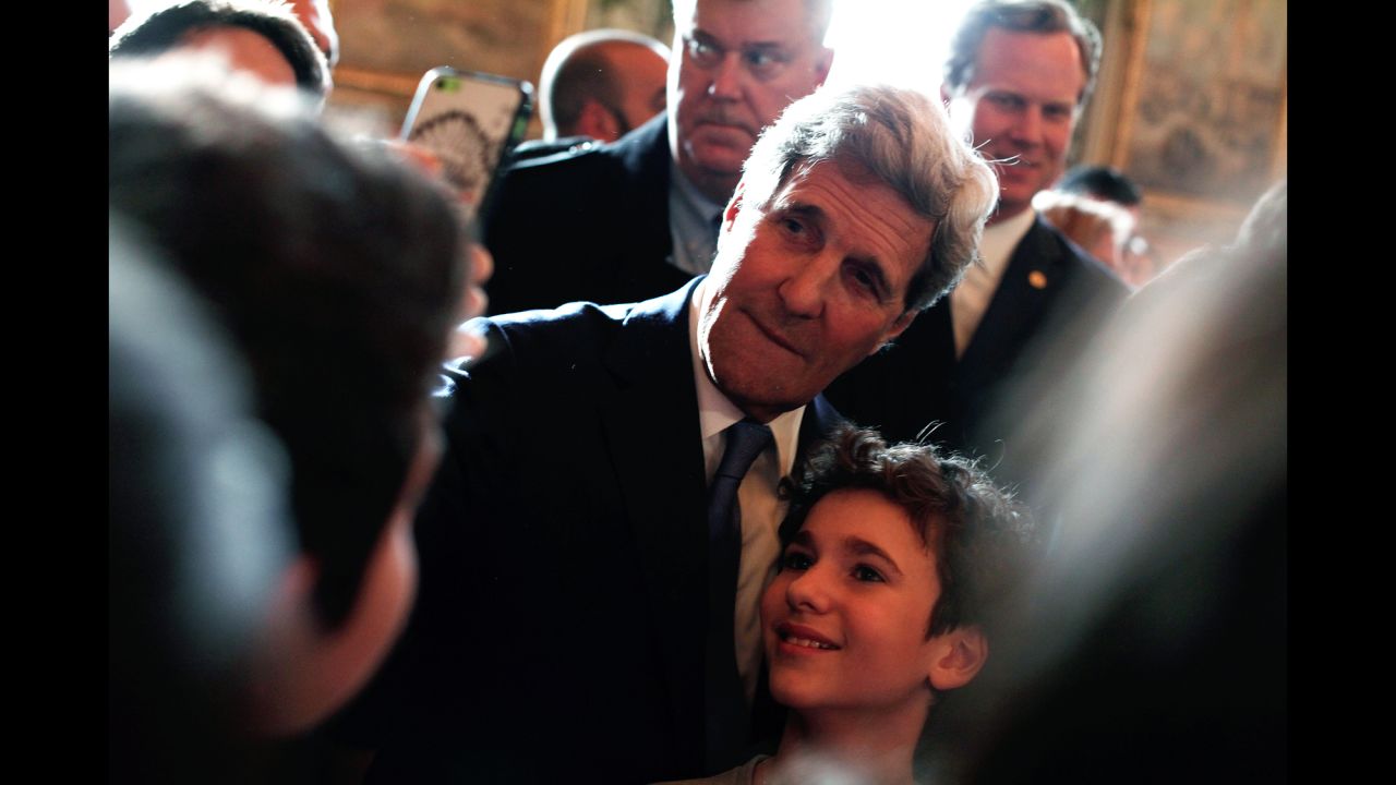 U.S. Secretary of State John Kerry poses with a boy after giving a speech at Paris' city hall on Friday, January 16.