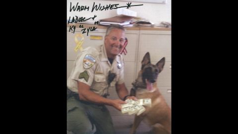 Sheriff Lee Dove autographed photos of himself with a bundle of money.