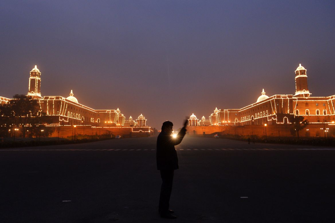 JANUARY 21 - NEW DELHI, INDIA: A policeman directs the traffic in front of the illuminated Central Secretariat building. India will celebrate its 65th Republic Day on January 26 with a large military parade. 