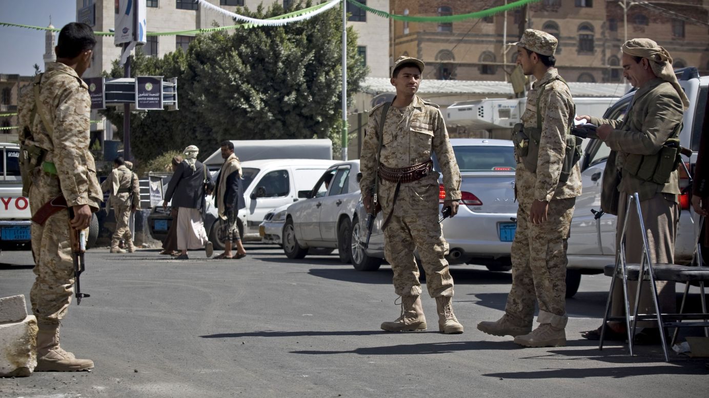 Houthi men wearing army uniforms stand guard on a street leading to the presidential palace in Sanaa on Wednesday, January 21. 