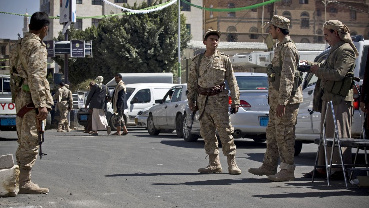 Houthi men wearing army uniforms stand guard on a street leading to the presidential palace in Sanaa on Wednesday, January 21.