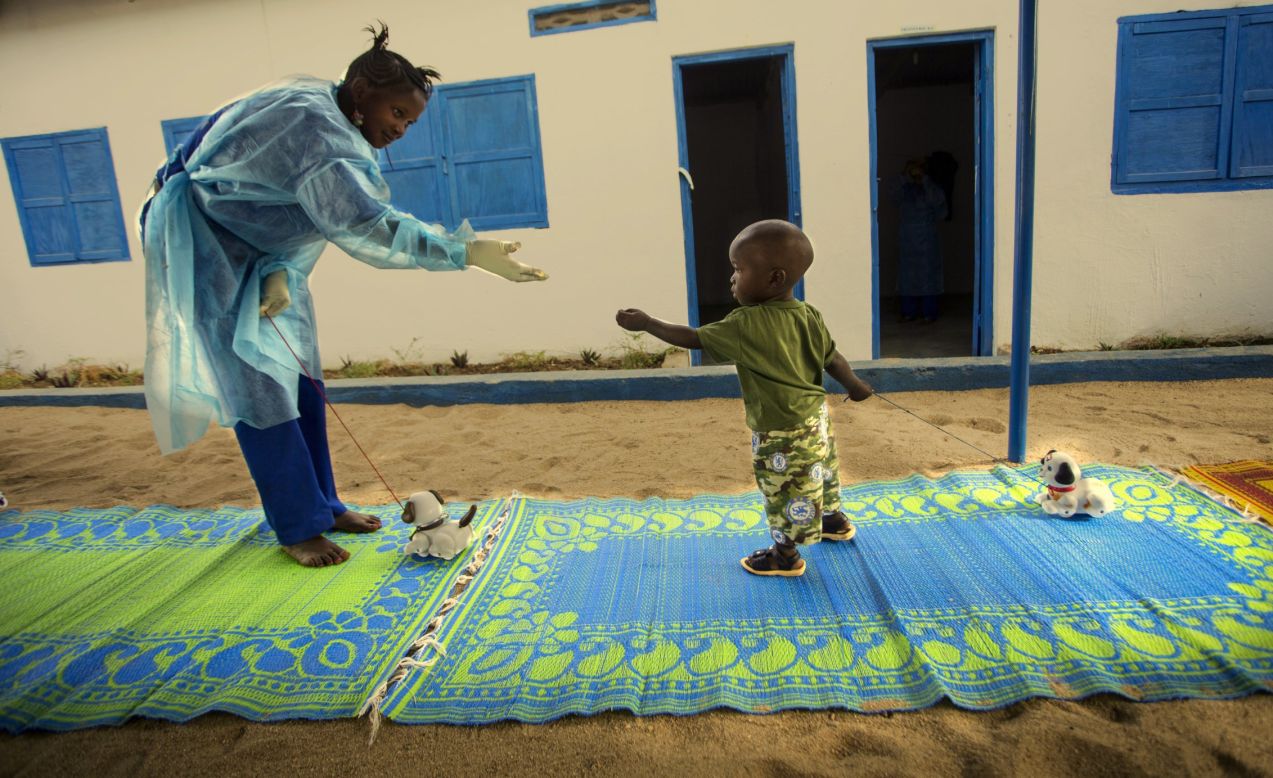 A worker at a UNICEF-supported Interim Care Center plays with 19-month-old Ebola survivor Tamba in Gueckedou, Forest Region, Guinea on January 11, 2015. Tamba's mother died of Ebola, then his father abandoned him for fear of catching the disease himself. UNICEF is working to break down the stigma around Ebola so children like Tamba still have homes to go to.  