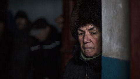 A Ukrainian woman waits for shelling to abate as she shelters inside a building.