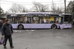 Local people inspect the scene of an explosion next to a bus stop in Donetsk.