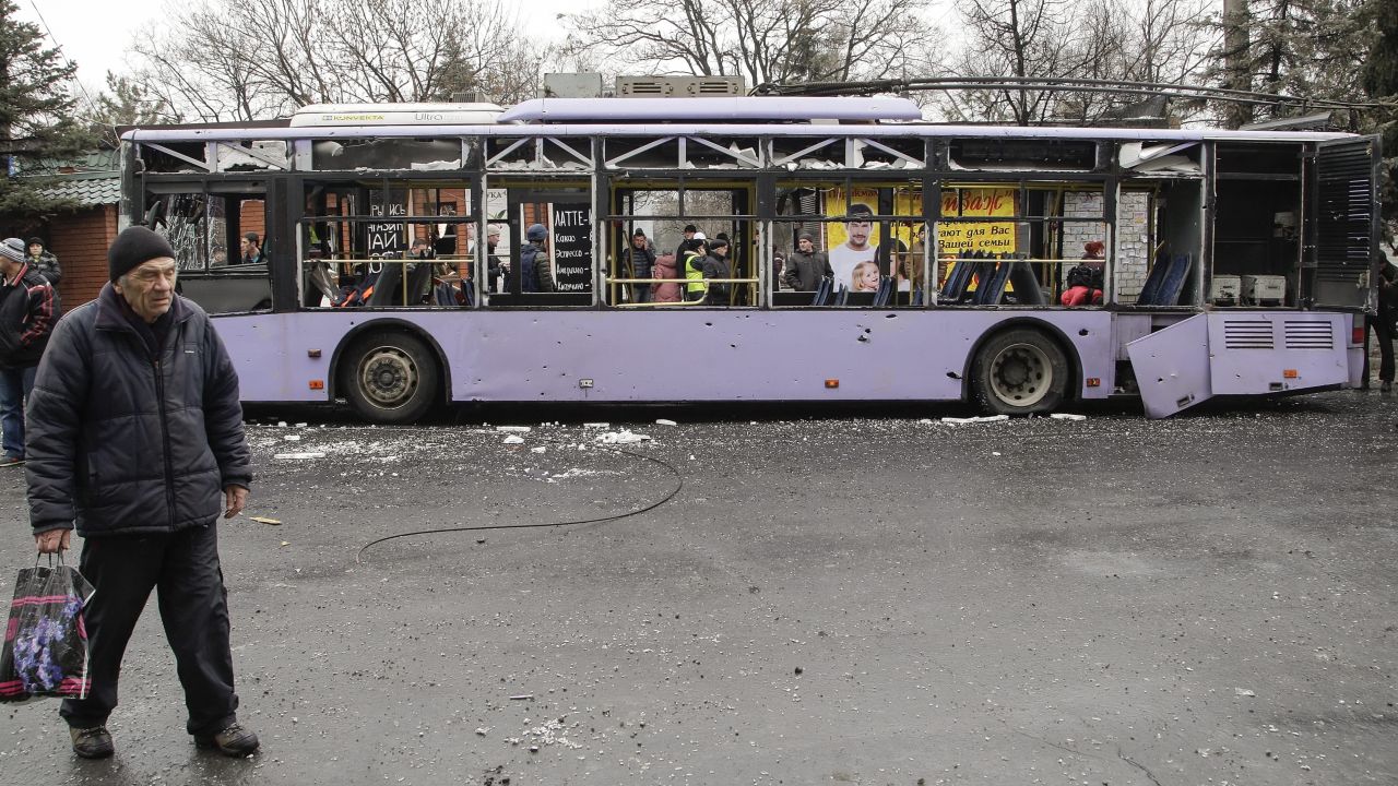Local people inspect the scene of an explosion next to a bus stop in Donetsk.